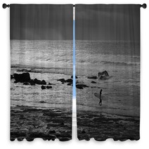 A Black And White Photo Of A Surfer Entering The Water At Golf Course Reef At Mollymook On The South Coast Of New South Wales In Australia Window Curtains 166523475