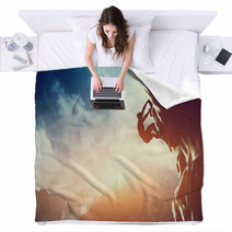 A Silhouette Of Man Climbing On Rock, Mountain At Sunset. Blankets 62334793
