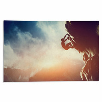 A Silhouette Of Man Climbing On Rock, Mountain At Sunset. Rugs 62334793