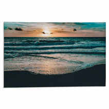 Bright Sun Rising In The Colorful Sky Over Dark Sand And Waves Rugs 176183048