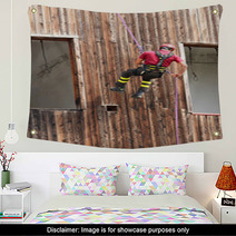 Firefighter Climber Down Into The Wall Of The House In Abseiling Wall Art 65583718