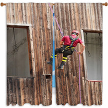 Firefighter Climber Down Into The Wall Of The House In Abseiling Window Curtains 65583718