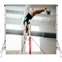 Girl Athlete Gymnast Exercises On Uneven Bars Backdrops 136677938