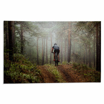 Male Athlete Mountainbiker Rides A Bicycle Along A Forest Trail In Forest Mist Mysterious View Rugs 117998340