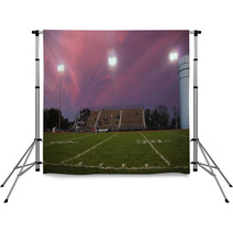 Pans Of A High School Football Stadium In Front Of A Beautiful Pink And Purple Sky Backdrops 137099092