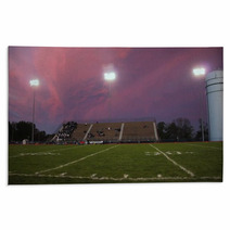 Pans Of A High School Football Stadium In Front Of A Beautiful Pink And Purple Sky Rugs 137099092