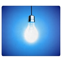 Single Lightbulb Shining A Bright Light On Blue Background Rugs 65162695