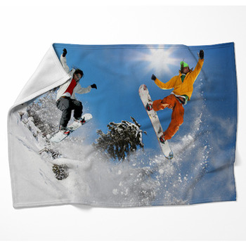 Snowboarders Jumping Against Blue Sky Woven Throw Blanket